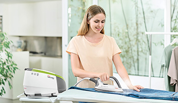 The image shows a girl ironing a pair of jeans with Polti Vaporella Next VN18.45