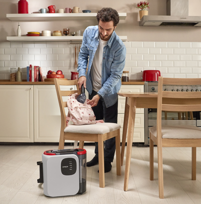 a man cleaning a sofa with a steam spot cleaner Polti