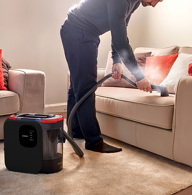 a man cleaning a sofa with a steam spot cleaner Polti